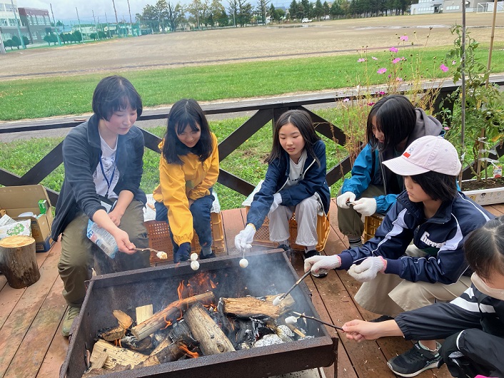 ワークショップで子どもたちとメンターが焚火を囲んでいる様子。